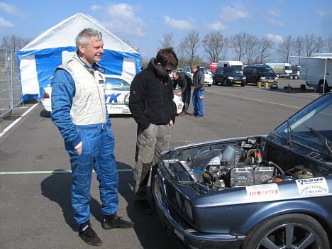Anders T. Jensen foran sin Youngtimer i klasse 2, klar til weekendens starbadser på Padborg Park, mens mekaniker Jon Back ser ned til motoren i BMW'en.